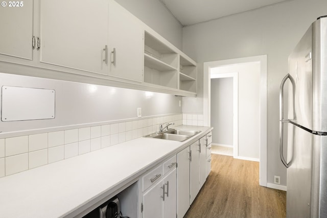 1963 Villard St, Eugene, OR 97403 - kitchen featuring freestanding refrigerator, light countertops, tasteful backsplash, light wood-type flooring, and white cabinetry