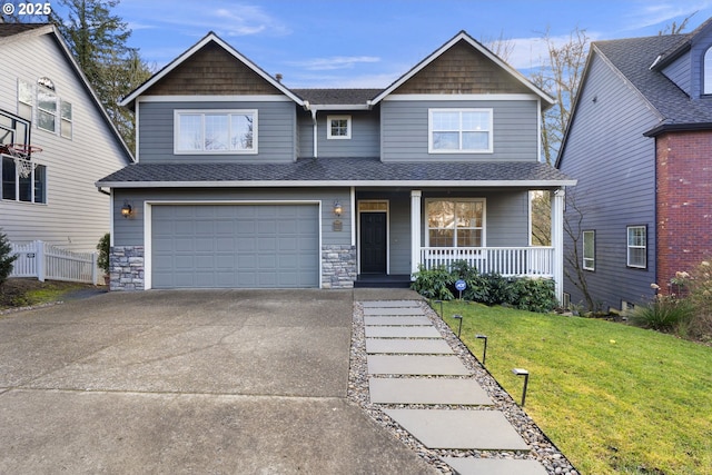 view of front of house with a garage, covered porch, and a front yard