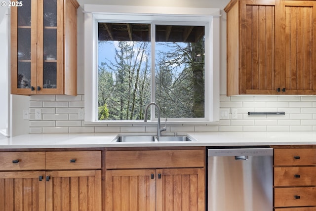 kitchen featuring sink, stainless steel dishwasher, and decorative backsplash