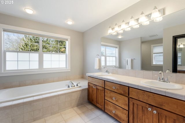 bathroom featuring tile patterned floors, vanity, and tiled tub