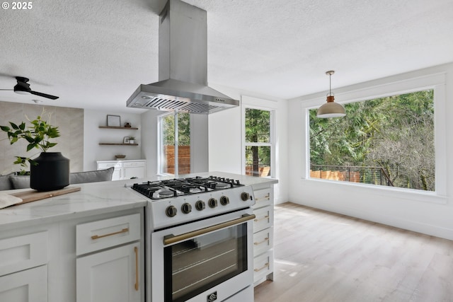 kitchen featuring a textured ceiling, extractor fan, white range with gas cooktop, and light stone countertops