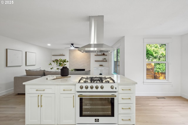 kitchen with white cabinetry, open floor plan, light wood finished floors, white gas range, and island exhaust hood