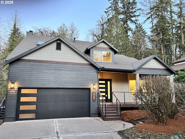 view of front facade featuring driveway, a shingled roof, a garage, and a porch