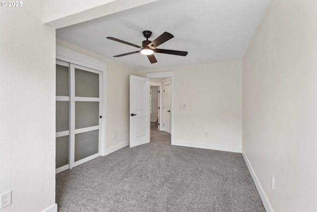 unfurnished bedroom featuring carpet, ceiling fan, and baseboards