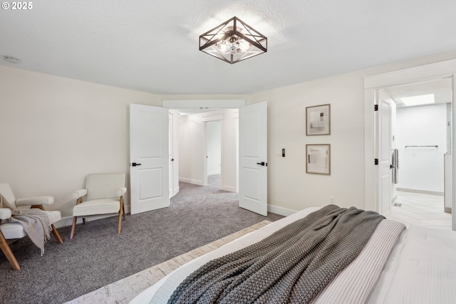 bedroom with light carpet, a textured ceiling, and baseboards