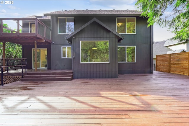 back of property featuring a wooden deck and fence