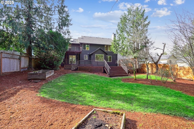 rear view of house featuring a fenced backyard, a yard, a vegetable garden, a wooden deck, and a chimney