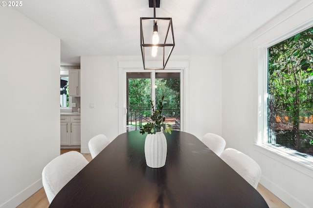 dining area with baseboards and light wood-style floors