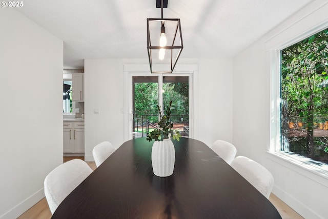 dining area featuring light wood-style floors and baseboards