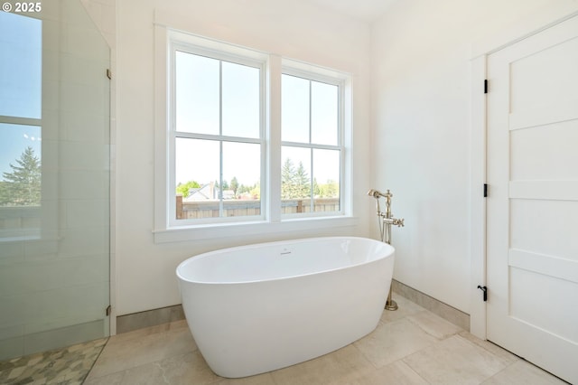 full bath featuring a freestanding tub and tiled shower