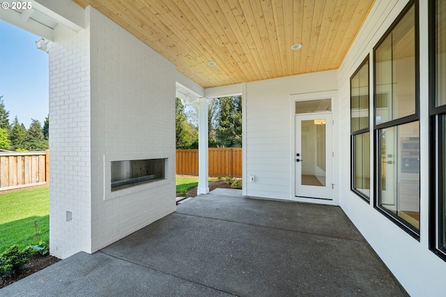 view of patio / terrace featuring a fenced backyard and an outdoor brick fireplace