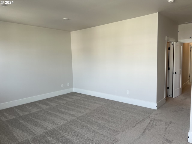 carpeted empty room with baseboards