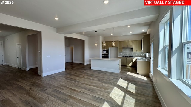interior space featuring stainless steel appliances, light countertops, a healthy amount of sunlight, decorative backsplash, and open floor plan