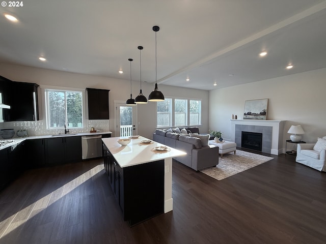 kitchen featuring dark cabinets, dark wood-type flooring, a sink, light countertops, and dishwasher