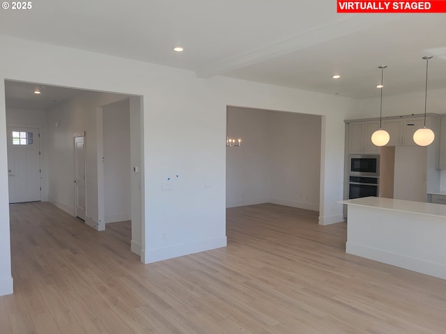 empty room with light wood-style floors, recessed lighting, and baseboards