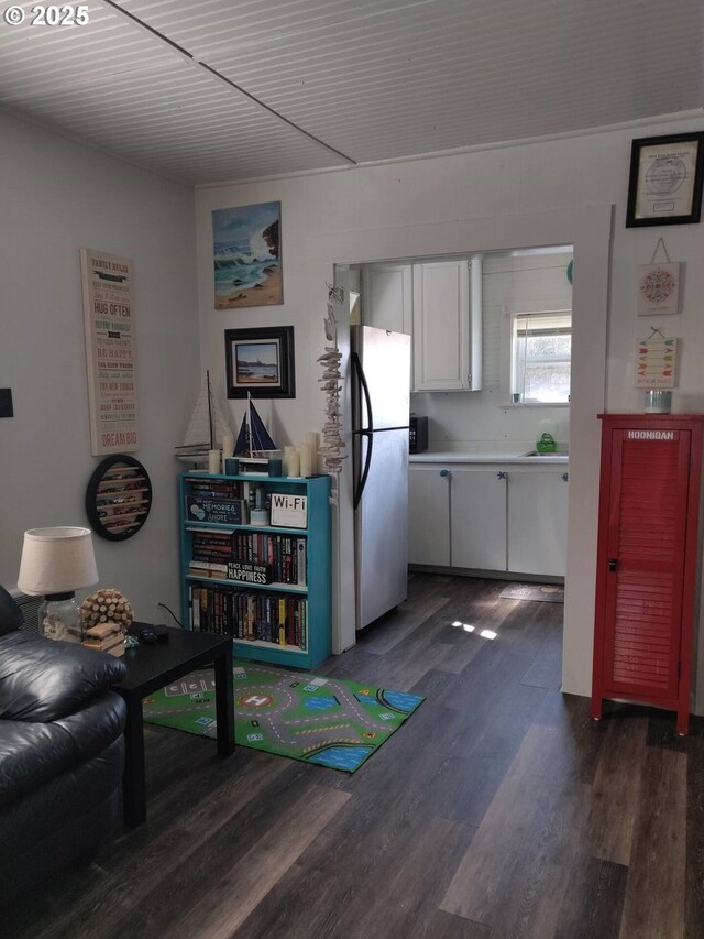 317 N Beacon St, Rockaway Beach, OR 97136 - interior space featuring white cabinets, stainless steel fridge, and dark wood-type flooring