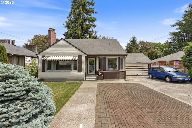 view of front of home featuring a garage, a shingled roof, and a chimney