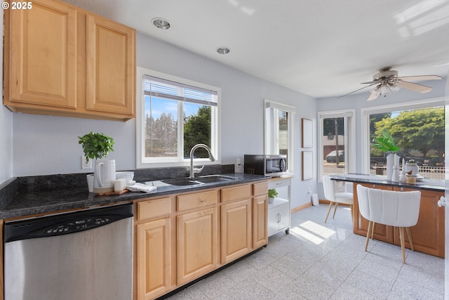 kitchen with appliances with stainless steel finishes, a sink, light brown cabinets, ceiling fan, and baseboards