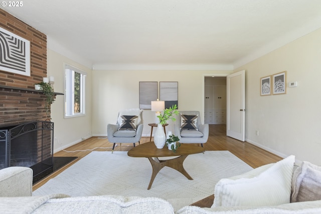 living room featuring wood finished floors, baseboards, and a fireplace