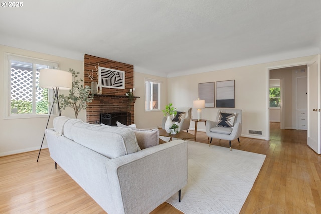 living area with light wood finished floors, baseboards, and a fireplace