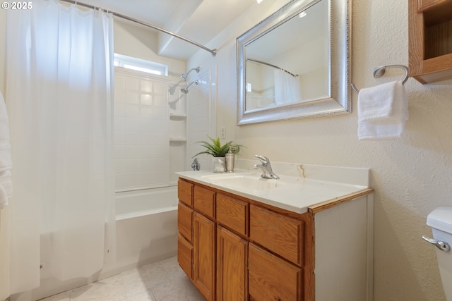 bathroom featuring shower / bath combination with curtain, vanity, toilet, and a textured wall