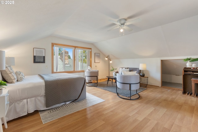 bedroom with light wood-style flooring, vaulted ceiling, and baseboards