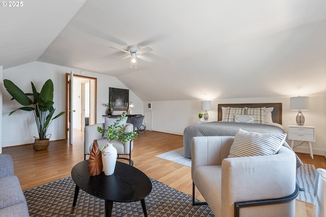 bedroom featuring baseboards, vaulted ceiling, and light wood finished floors
