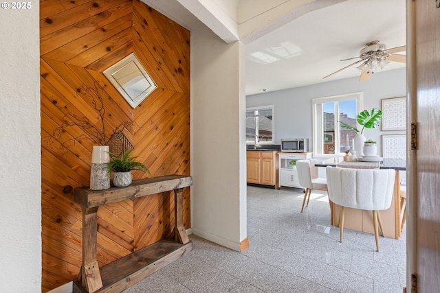 corridor with granite floors, baseboards, and a sink