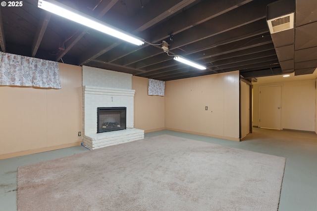 finished basement with a brick fireplace