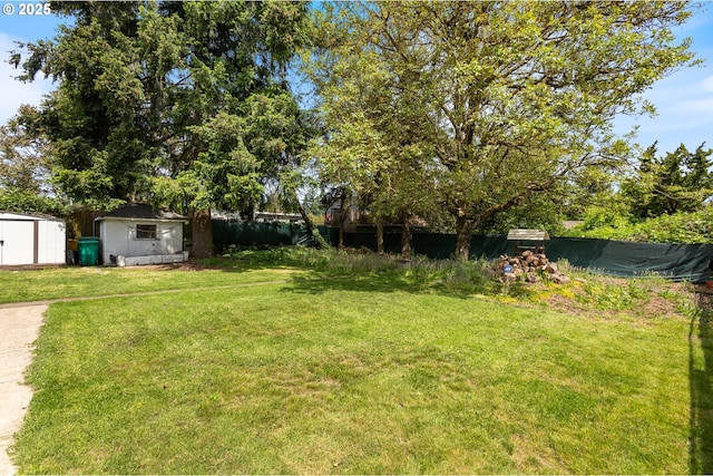 view of green lawn featuring a shed and an outdoor structure