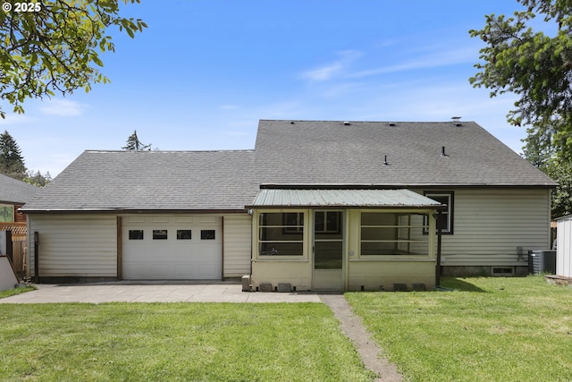 rear view of property featuring a garage, a patio area, a lawn, and roof with shingles