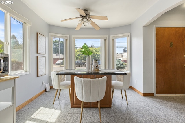 dining room with granite tiled floors, baseboards, and ceiling fan