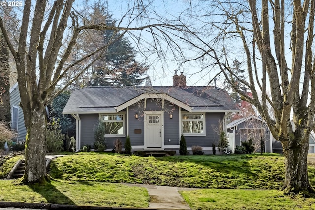 view of front of home featuring a chimney and roof with shingles