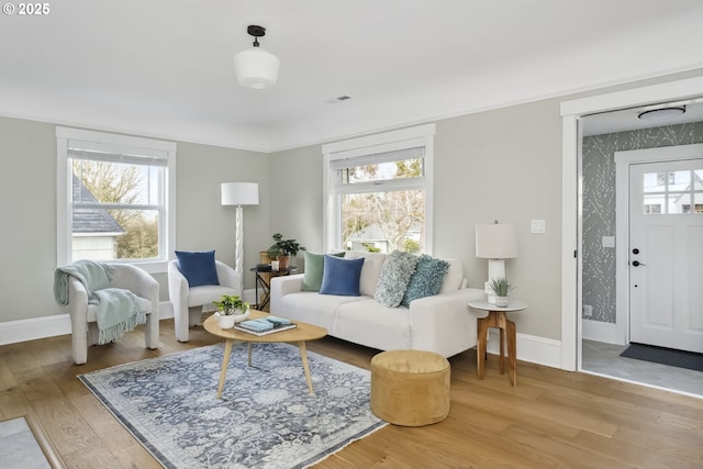 living room featuring baseboards, light wood-style flooring, and wallpapered walls