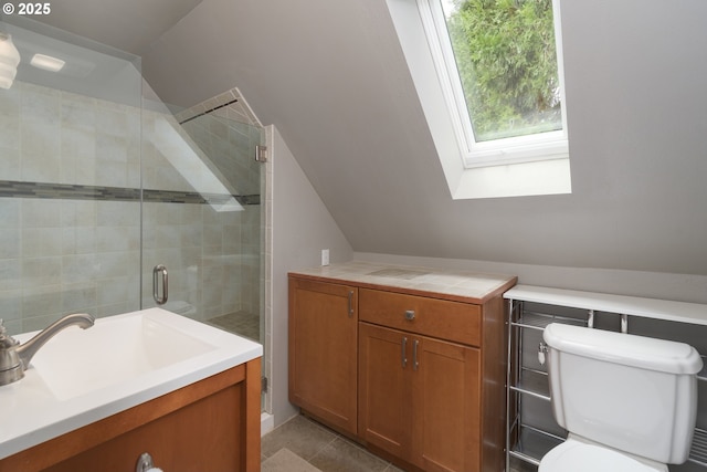 bathroom with lofted ceiling, a stall shower, a sink, toilet, and a skylight