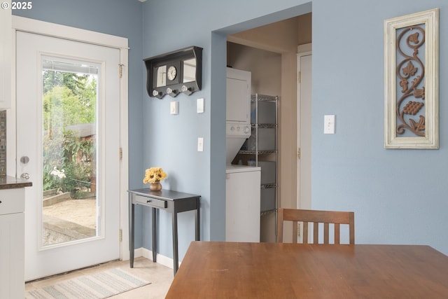 dining space with stacked washer and clothes dryer