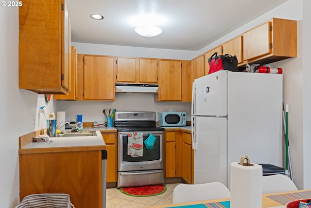 9 N 20th St, Hood River, OR 97031 - kitchen featuring electric range, freestanding refrigerator, a sink, under cabinet range hood, and light countertops