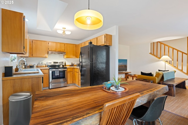 9 N 20th St, Hood River, OR 97031 - kitchen with stainless steel electric range oven, freestanding refrigerator, a sink, light countertops, and under cabinet range hood