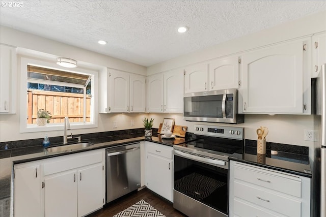 180 Nelson Ln, Gladstone, OR 97027 - kitchen featuring stainless steel appliances, a sink, dark countertops, a textured ceiling, and recessed lighting
