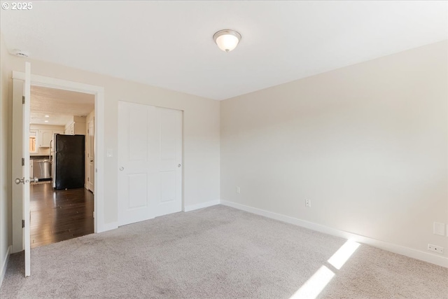 180 Nelson Ln, Gladstone, OR 97027 - unfurnished bedroom featuring freestanding refrigerator, carpet floors, baseboards, and a closet