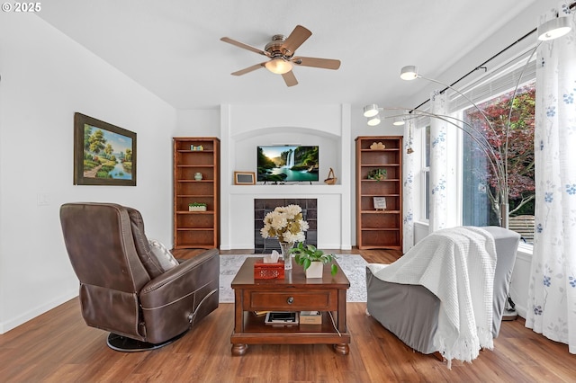 16085 SW Towhee Ln, Beaverton, OR 97007 - living area featuring ceiling fan, wood finished floors, a fireplace, and baseboards