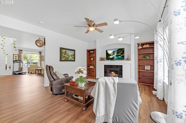 16085 SW Towhee Ln, Beaverton, OR 97007 - living room with built in shelves, ceiling fan, wood finished floors, and a tile fireplace