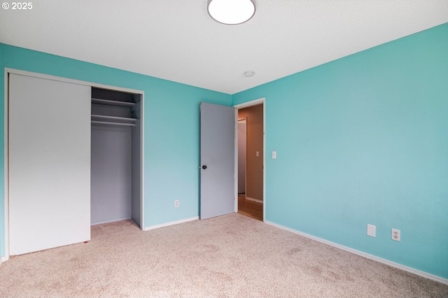 unfurnished bedroom with a closet, baseboards, and carpet floors