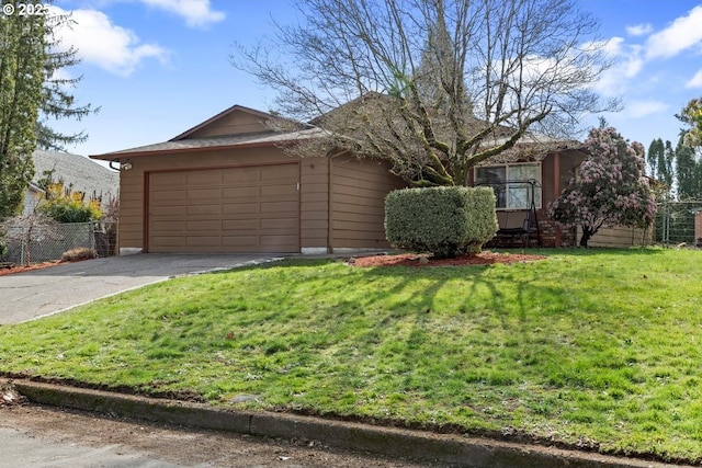 view of front of property featuring a front yard, fence, a garage, and driveway