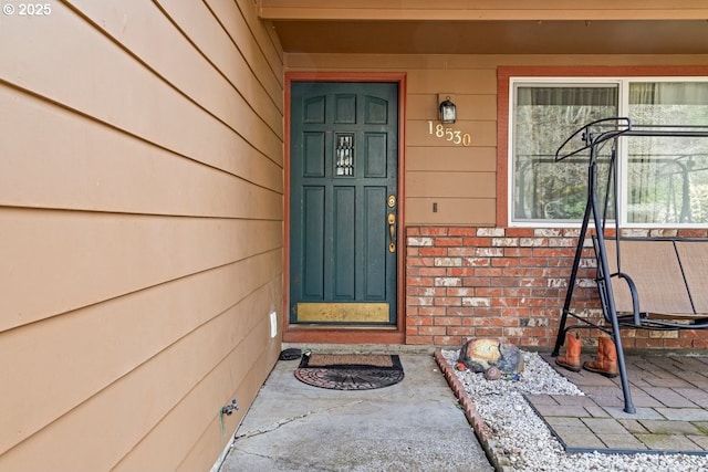 property entrance featuring brick siding