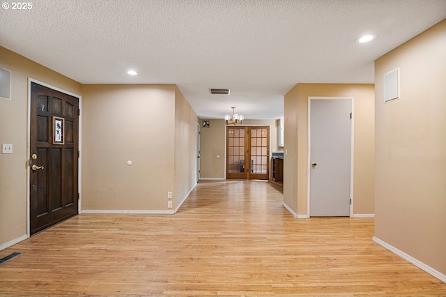 entrance foyer featuring visible vents, baseboards, recessed lighting, light wood-style floors, and a textured ceiling