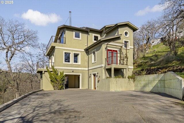 625 Columbia Ave, Lyle, WA 98635 - view of front facade with a balcony, stucco siding, a carport, and driveway