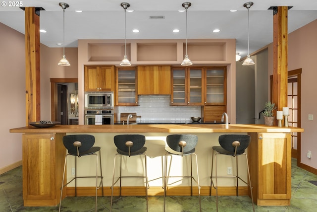 625 Columbia Ave, Lyle, WA 98635 - kitchen with stainless steel appliances, wooden counters, brown cabinets, baseboards, and decorative backsplash
