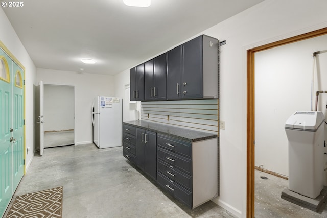 625 Columbia Ave, Lyle, WA 98635 - kitchen featuring freestanding refrigerator, concrete flooring, dark cabinetry, and baseboards
