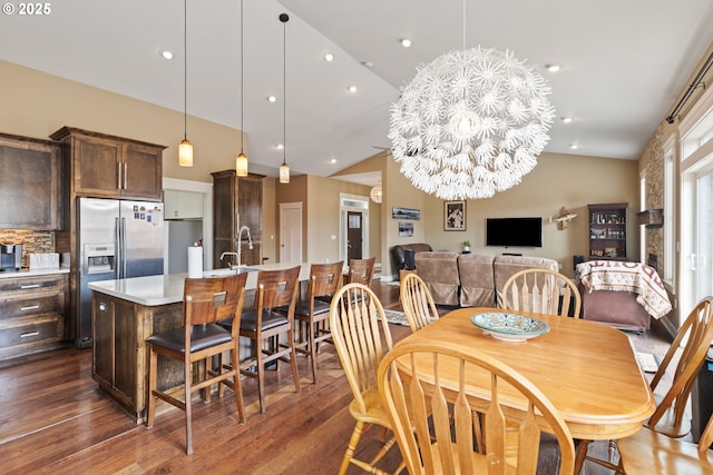 dining space featuring dark wood finished floors, vaulted ceiling, a chandelier, and recessed lighting